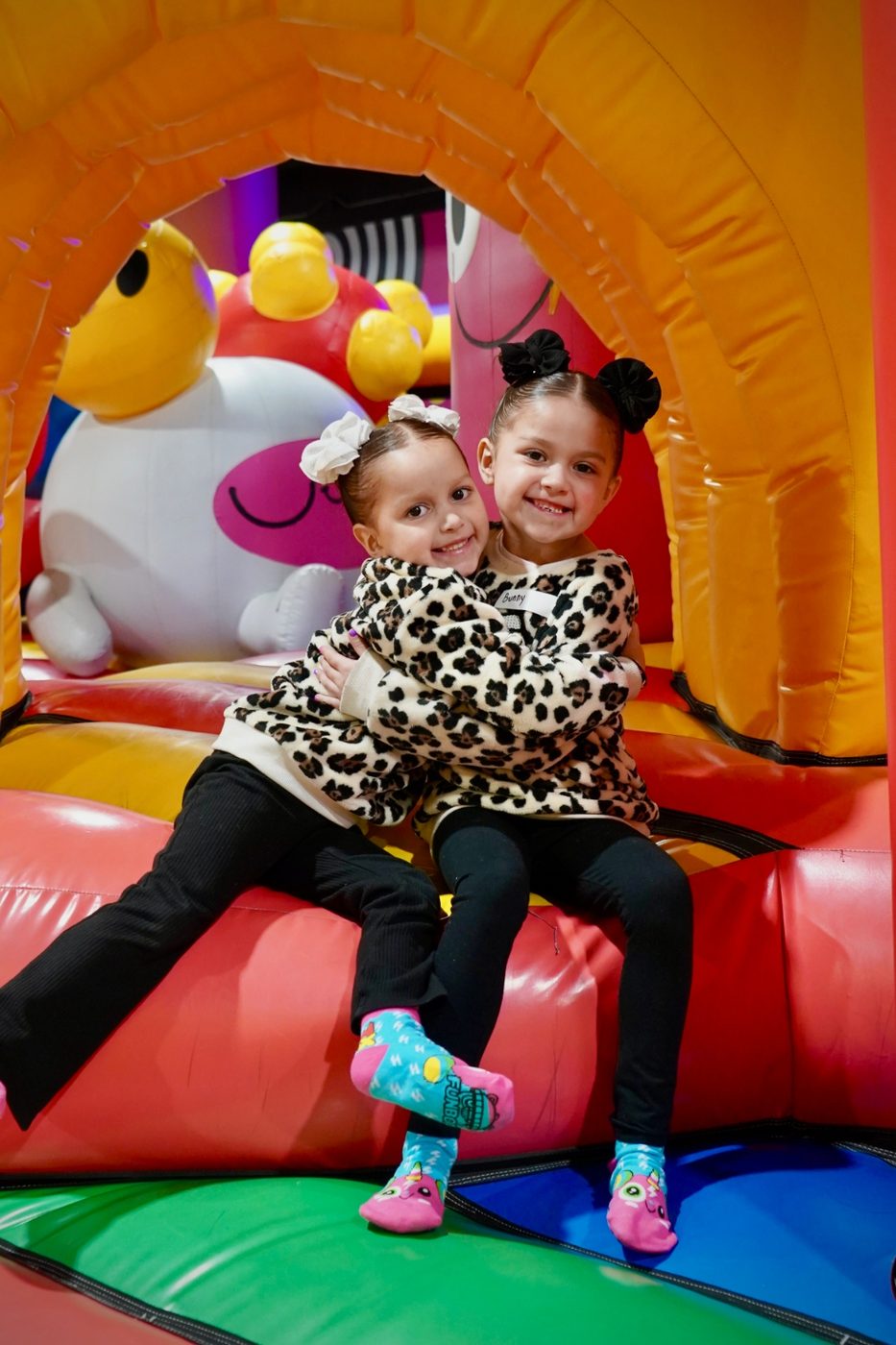 Two girls sitting inside an inflatable arch at FUNBOX