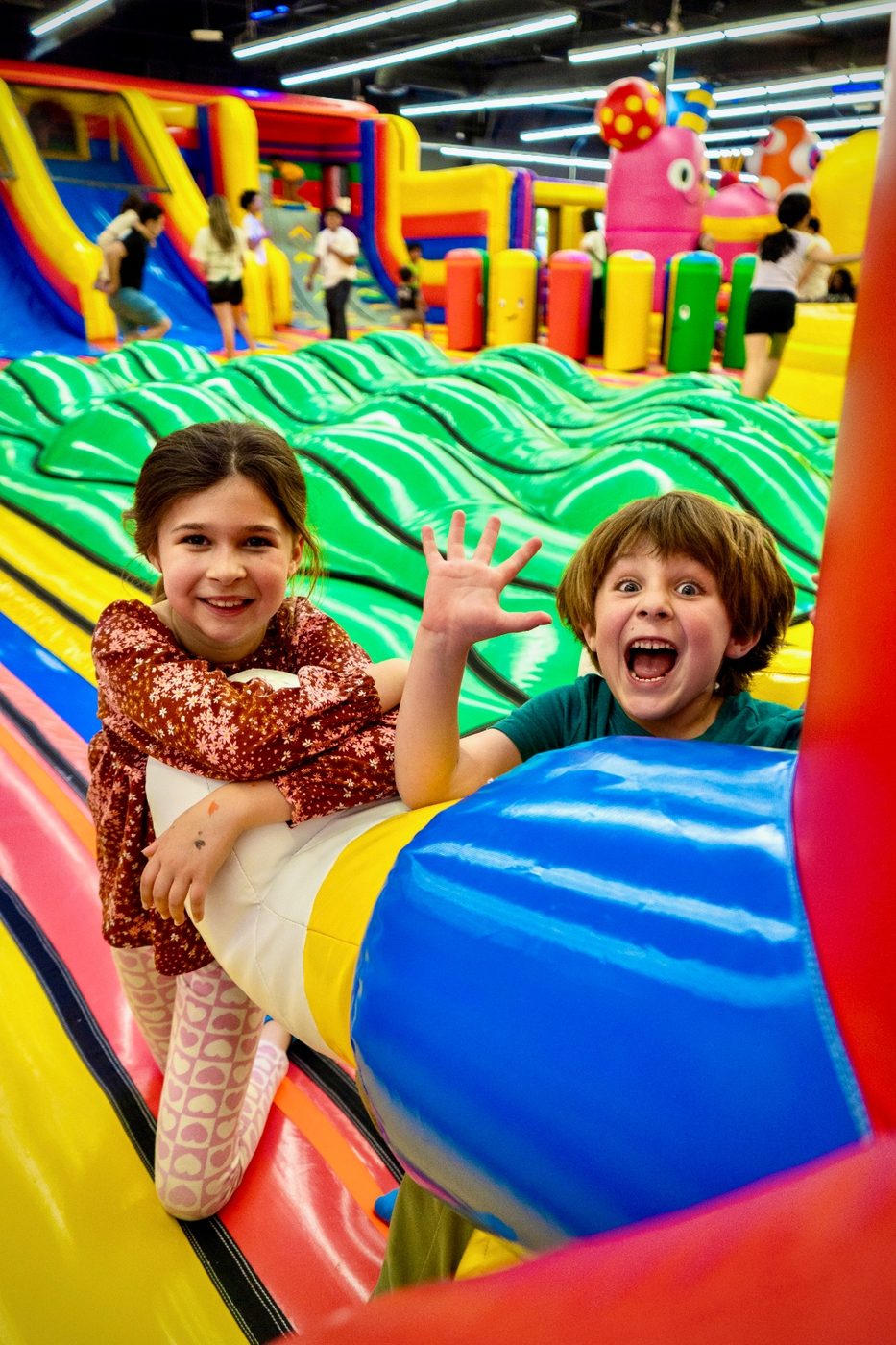 Two kids laughing at the bottom of a slide in the FUNBOX bounce park