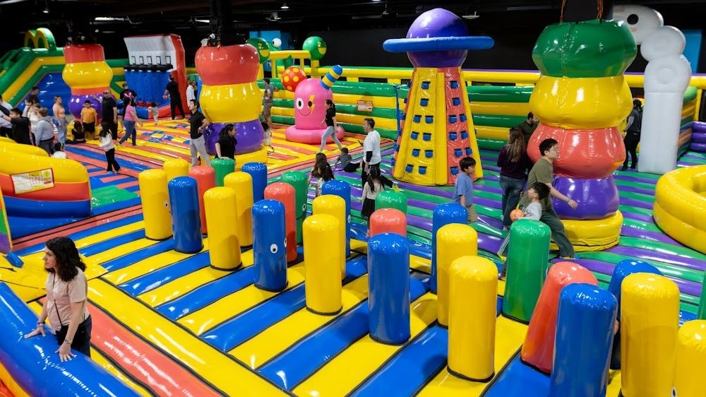 Families playing across the giant inflatable park at FUNBOX Houston
